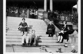 Three women, two children and two dogs seated on steps 1185 Harwood Street