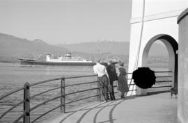 [People watching ship in harbour from Brockton Point]