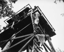 Liquor Board picnic [picnickers climbing water tower, possibly Bowen Island]