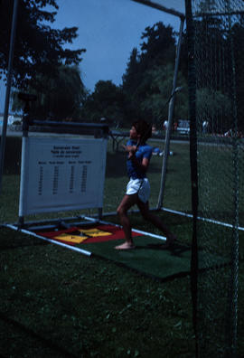 [Boy with golf club in golf net]