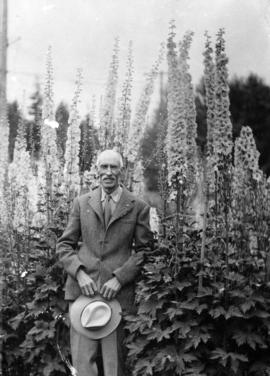 James L. Quiney [in front of delphiniums at] 4916 Union Street, Burnaby