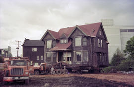 [Wide view of Hodson House raised on wheels during house relocation, 1 of 3]