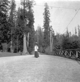 [Woman on path at entrance to Stanley Park]