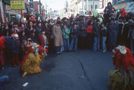 Spectators viewing colourful creatures in the Chinese New Year parade on Pender Street