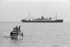 [A fishing boat and a freighter]