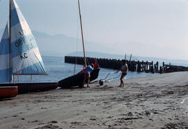 Couple hauling in sailboat at Jericho Beach [Locarno Beach]