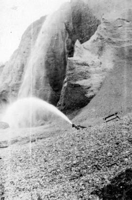 [Waterfall and water jet at placer gold mine]