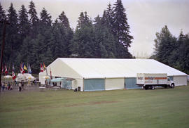 Flags in front of white and blue event tent