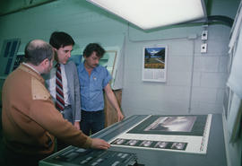 Toni Onley (left) and group examine his Centennial Art Series print at Agency Press