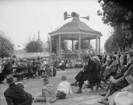 Canada Pacific Exhibition [A crowd sitting around the bandstand while a band is performing]