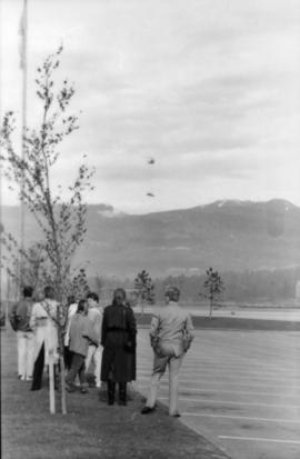 Group watching helicopter from parking lot