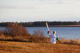 Day 24 Torchbearer 117 Cathy Williams carrying the flame in Lennox Island, Prince Edward Island.