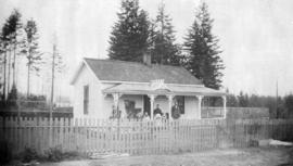 [James Hutson and family in front of cottage on the northeast corner of Cemetery (North Arm) Road...