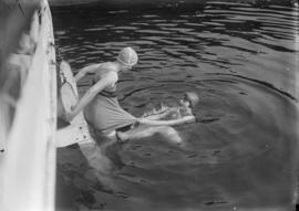 Two women swimming off a dock