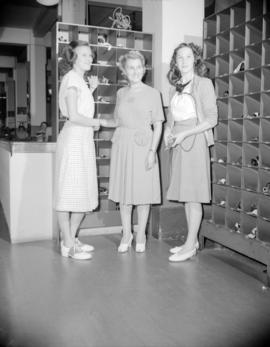 [Three B.C. Telephone operators standing by the headset storage area]