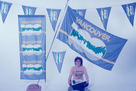Woman posing with Vancouver Centennial promotional materials