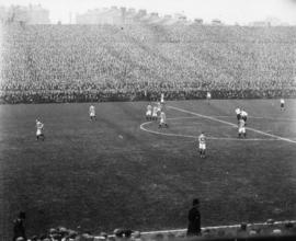 [A football match in a crowded stadium]