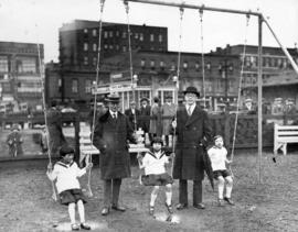 [Mayor L.D. Taylor with children and unidentified man at opening of children's playground at Carr...