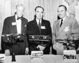 [Three members of The Early Bird Club in front of model airplanes]