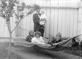 [Older man and five young children at hammock outside Robert Scott residence, southwest corner of...