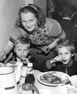 [Hungarian refugees have a meal in the Immigration Building at the airport]