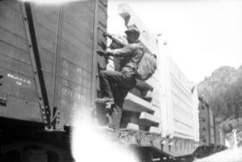 Man climbing onto freight train car