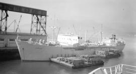 M.S. Nordpol [at dock, with lumber-filled barges alongside]