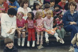 Children wearing face paint seated in bleachers