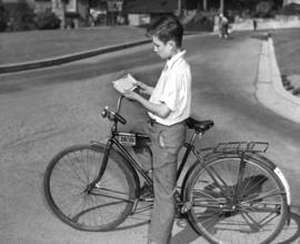 [A boy examines his new bicycle license]