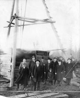 [Group portrait of L.D. Taylor standing with other men in front of a wooden structure with pulleys]