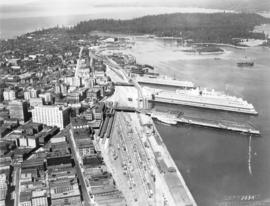 [Aerial view of downtown Vancouver showing showing C.P.R Pier D and Pier B-C looking west to Stan...