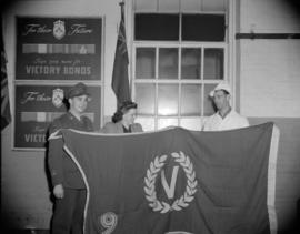 [Burns' Meats employee holding a victory bonds flag with a woman and a man in military uniform]