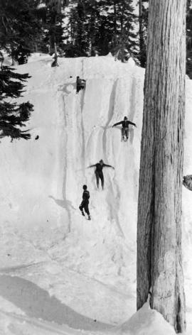 Figures sliding down snow-covered hill, Grouse Mountain