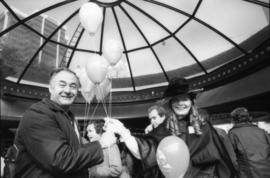 Don Bellamy and woman in costume holding balloons