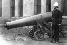 Sentry from The Duke of Connaught's Own Rifles beside cannon outside the Beatty Street Drill Hall