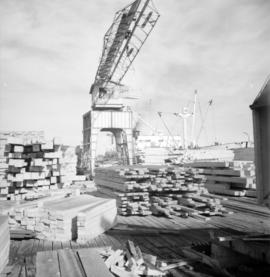 [View of the crane and piles of lumber at H.R. McMillan Co.]