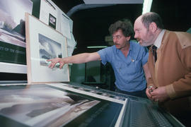 Toni Onley (right) and man examine his Centennial Art Series print at Agency Press