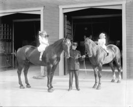 [Firehall no. 11 with fireman and girls sitting on horses]