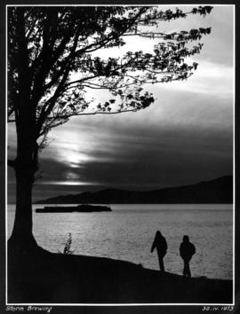 Storm brewing [couple walking along the beach]