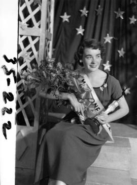 Portrait of Nancy Hansen, Miss P.N.E. 1954, posing with trophy and flowers