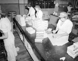 [Woman packaging paper napkins for] Pacific Mills