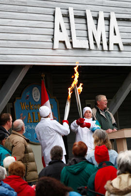 New Day 26 Torchbearers pass the flame at a Community Stop in Alma, New Brunswick.