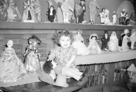 [Beverly Diane Rogers seated among part of Mrs. George R. Matthews doll collection]