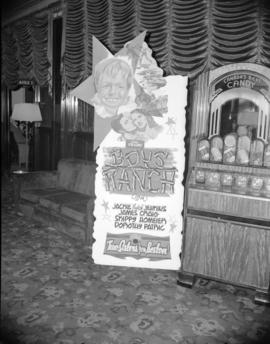[Poster advertising "Boy's Ranch" beside a candy machine in the lobby of the Strand The...