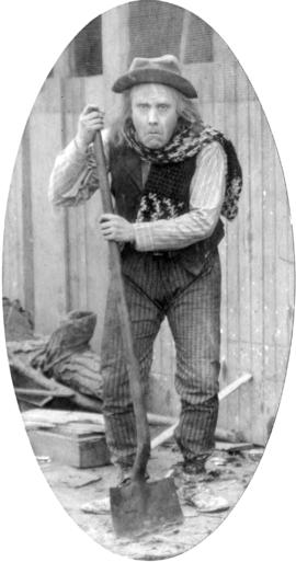 [Alfred T. Layne, actor, in role of old village idiot with shawl]