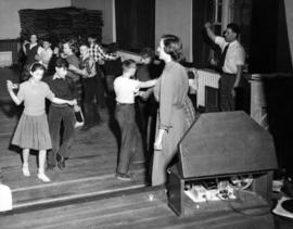 Square dancing in gym in old building, Stuart McRae, teacher