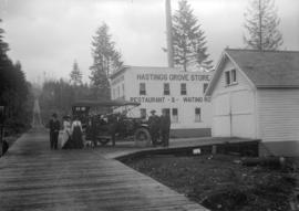 [Group of people assembled around a car in front of the Hastings Grove Store, Curtis and Duthie S...