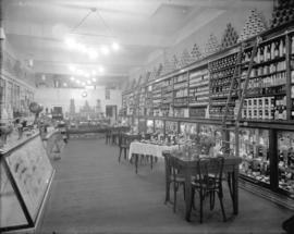 [Interior of grocery store, showing merchandise on shelves, counters and tables]