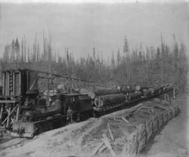 [Men posing with Great Northern Railway engine and flatbed cars with logs]