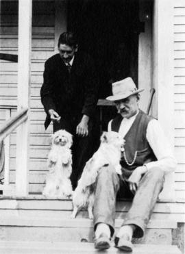 [Two men and dogs on a porch]